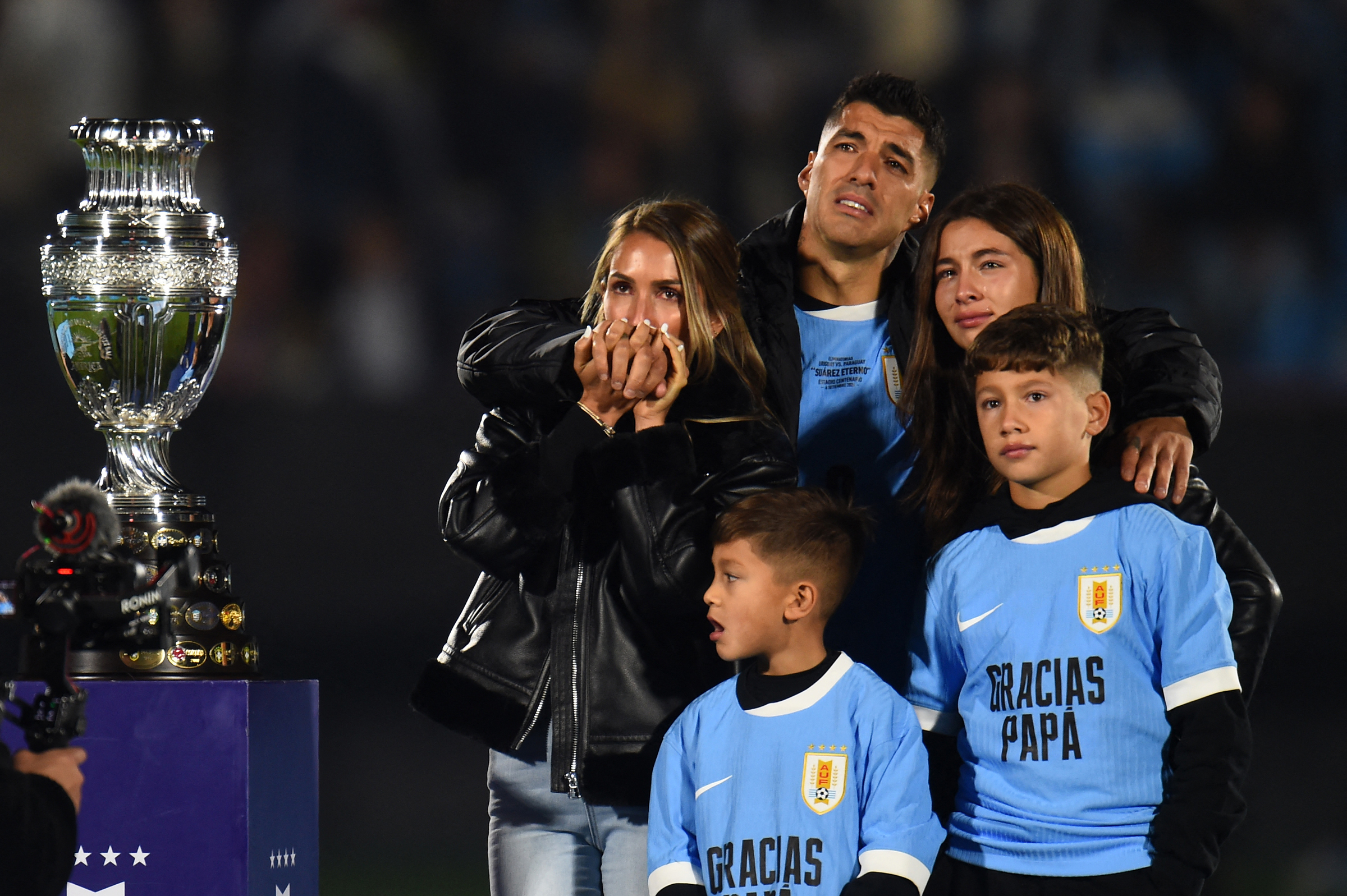 Luis Suarez khóc khi đứng cạnh vợ Sofia Balbi (trái) và các con Delfina (phải), Lautaro (giữa), và Benjamin bên bản sao cup vô địch Copa America trong buổi lễ tri ân anh ở trận đấu cuối cùng cho tuyển Uruguay trên sân Centenario, Montevideo ngày 6/9. Ảnh: AFP